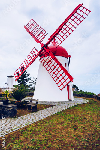Old windmill Red Peak Mill in Bretanha (Sao Miguel, Azores). Traditional white wind mill with red roof and wings in village Bretanha, Sao Miguel Island, Azores, Portugal. photo