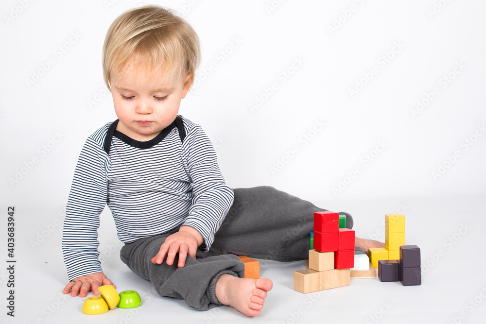 Little baby boy is playing with colourfull wooden block isolated on white background. Education and learn game concept with copy space. Little baby boy is playing with colourfull wooden block isolated on white background. Education and learn game concept with copy space.
