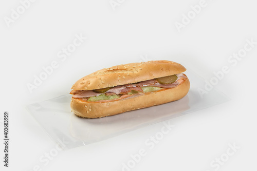 Baguette stuffed with chicken vegetables and cheese on a gray background