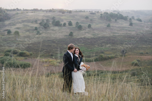 Romantic, young and happy caucasian couple in wedding clothes on the background of beautiful nature. Love, relationships, romance, happiness concept. Bride and groom traveling together.