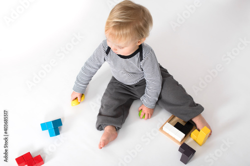 child playing with wooden colorful blocks, top view