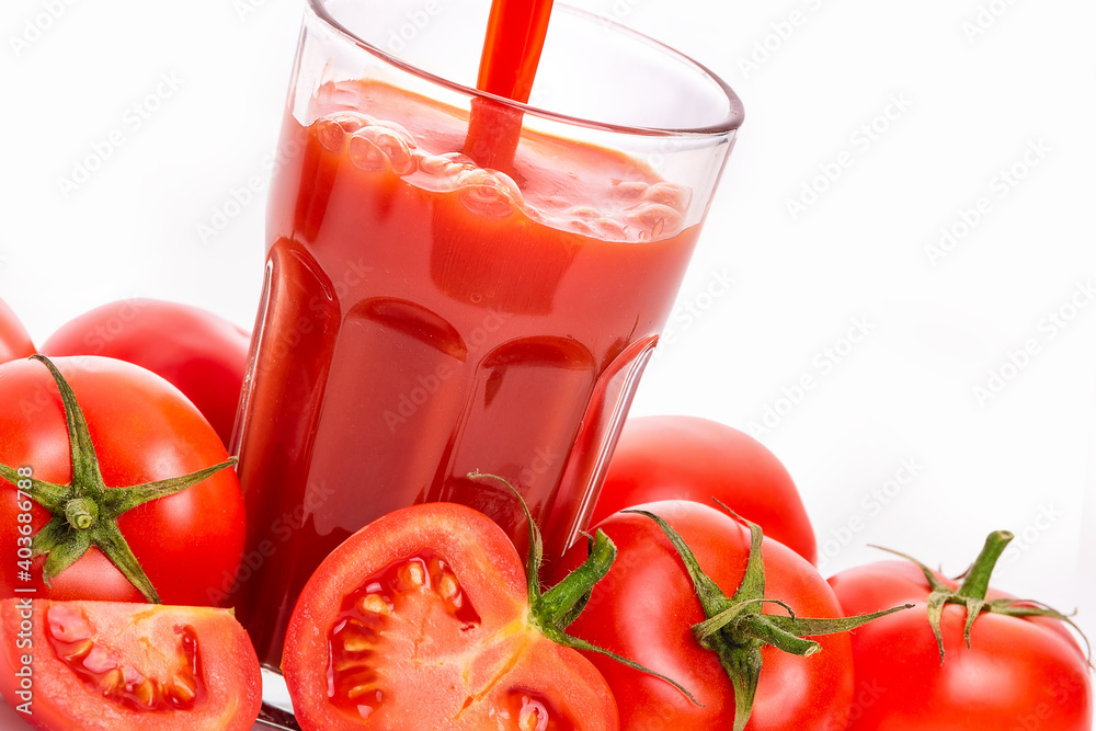 Tomato juice in a glass and tomatoes with green sepals. isolate on white background Tomato juice in a glass and tomatoes with green sepals. isolate on white background