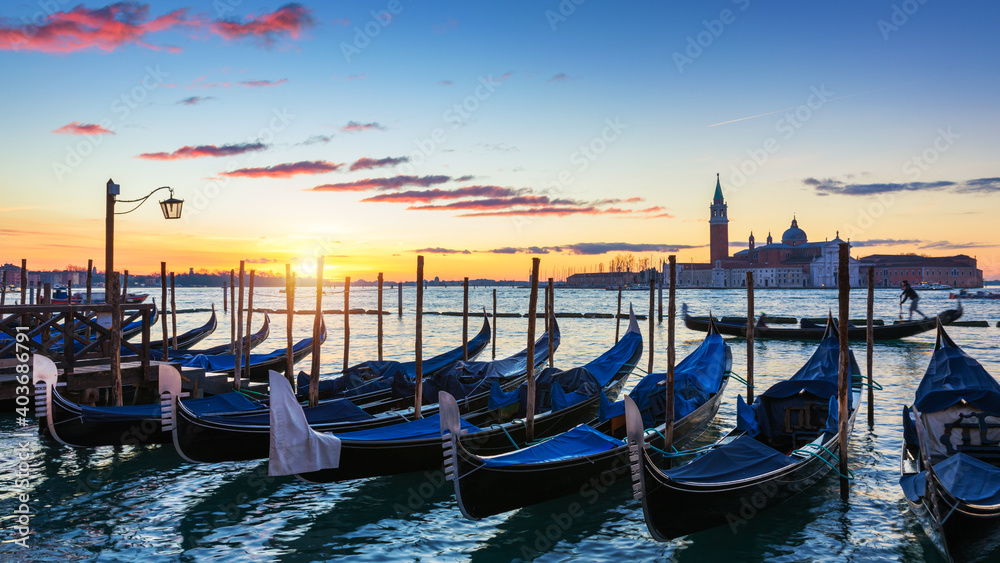 Scenic view of San Giorgio Maggiore, gondolas and lamp at colorful sunrise, Venice, Italy. Sunset in Venice. Gondolas at Saint Mark's Square and church of San Giorgio Maggiore