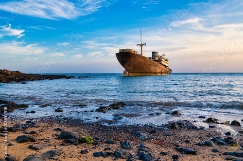 Obraz na plátně Old wrecked ship in blue ocean, in the town of Arrecife on the island of Lanzaro