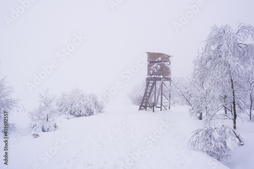 hunting tower in snowy and foggy forest