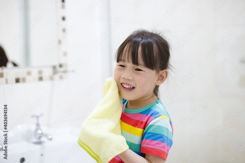 young girl washing face by herself in bathroom young girl washing face by herself in bathroom