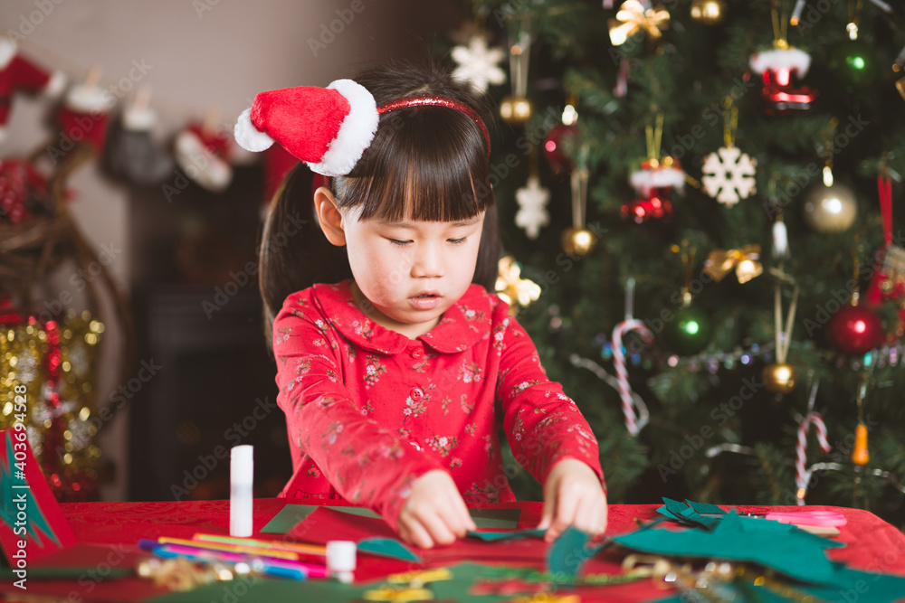 young girl making christmas craft at home