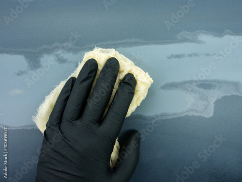 Slika na platnu the hand of the auto painter in a black glove holds a special napkin for dusting the surface of the car
