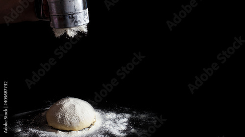 Valokuva the chef sprinkles flour on the dough