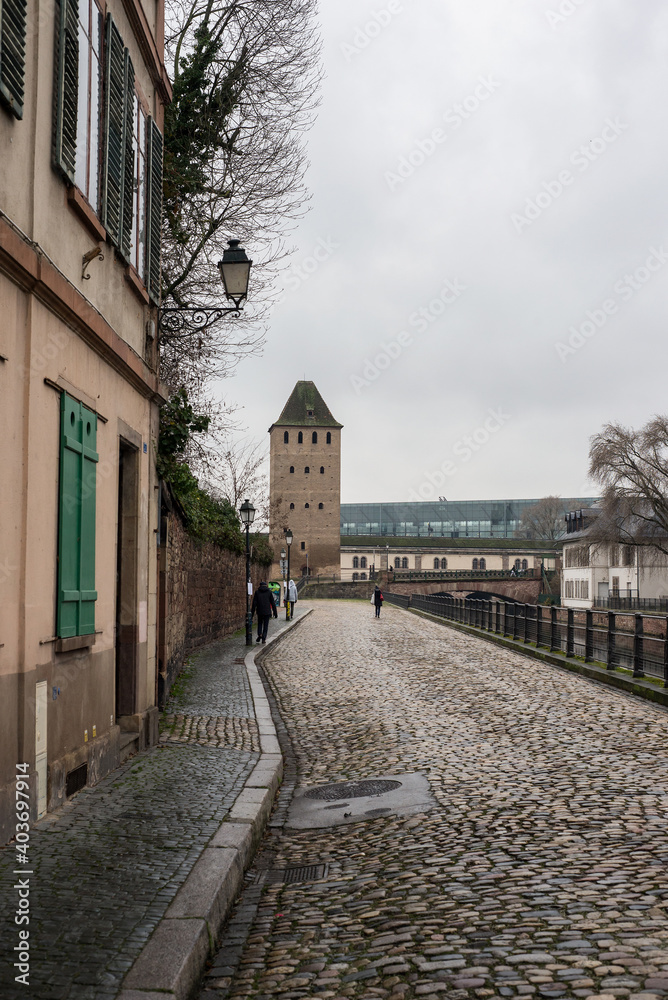 view of cobblestone street on stoned tower background at little france quarter in Strasbourg by winter