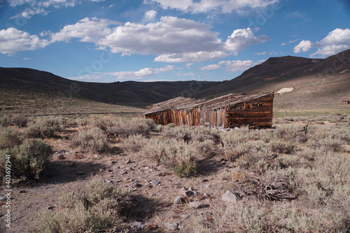 Abandoned buildings at the abandoned Bodie ghost town in the Sierra Nevada mountains of California on a sunny day with clouds