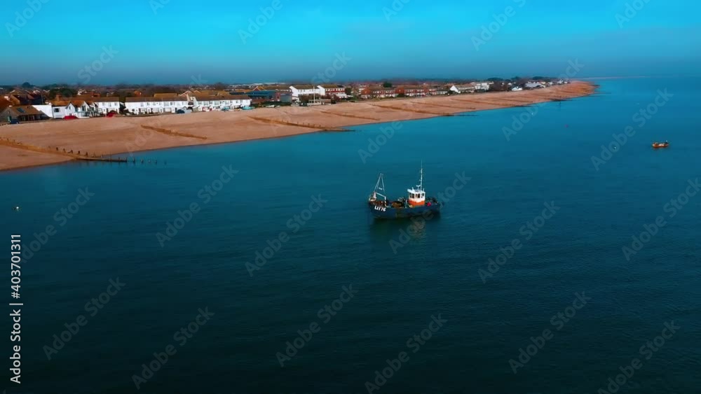 Aerial of a local fishing boat anchored off East Beach in Selsey England on a sunny and clear winters day. Aerial of a local fishing boat anchored off East Beach in Selsey England on a sunny and clear winters day.