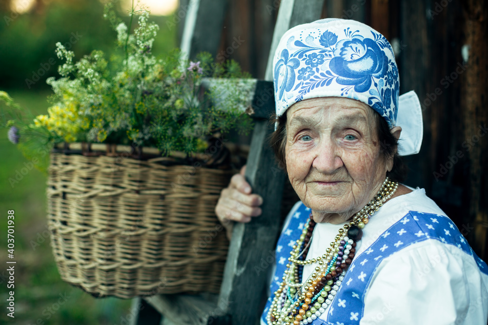 Portrait of old woman in ethnic clothes in the russian village.