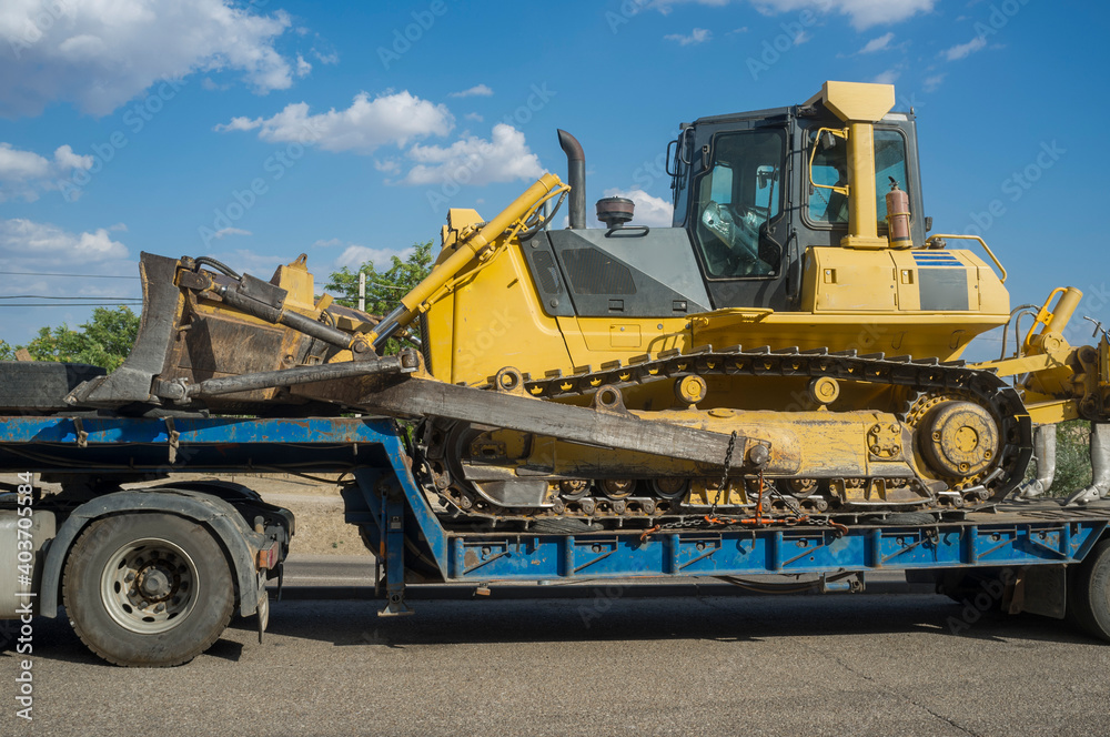 Heavy-duty truck carrying bulldozer equipped with multishank ripper