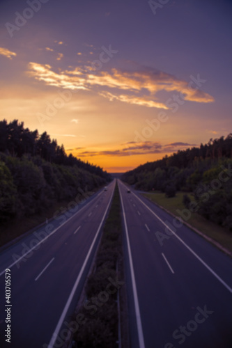 Highway through the forest with empty lanes at sunset  © martinlisner