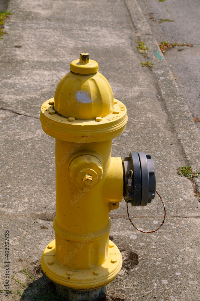 Yellow fire hydrant. Fragment of the pavement on the street. Yellow fire hydrant. Fragment of the pavement on the street.