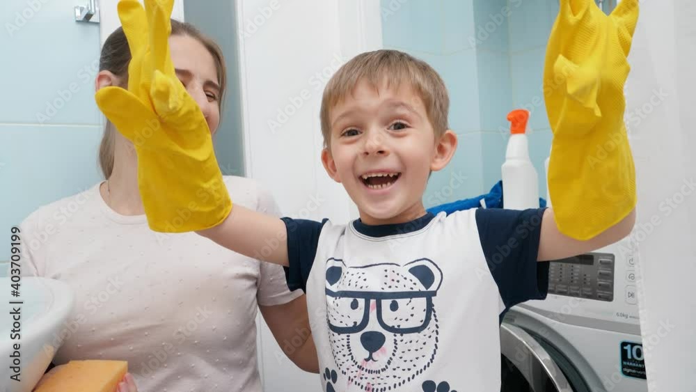 Foing Funny laughing boy wearing yellow rubber gloves laughing and making ...