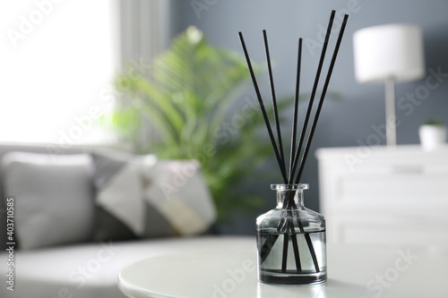 Aromatic reed air freshener on white table in room. Space for text
