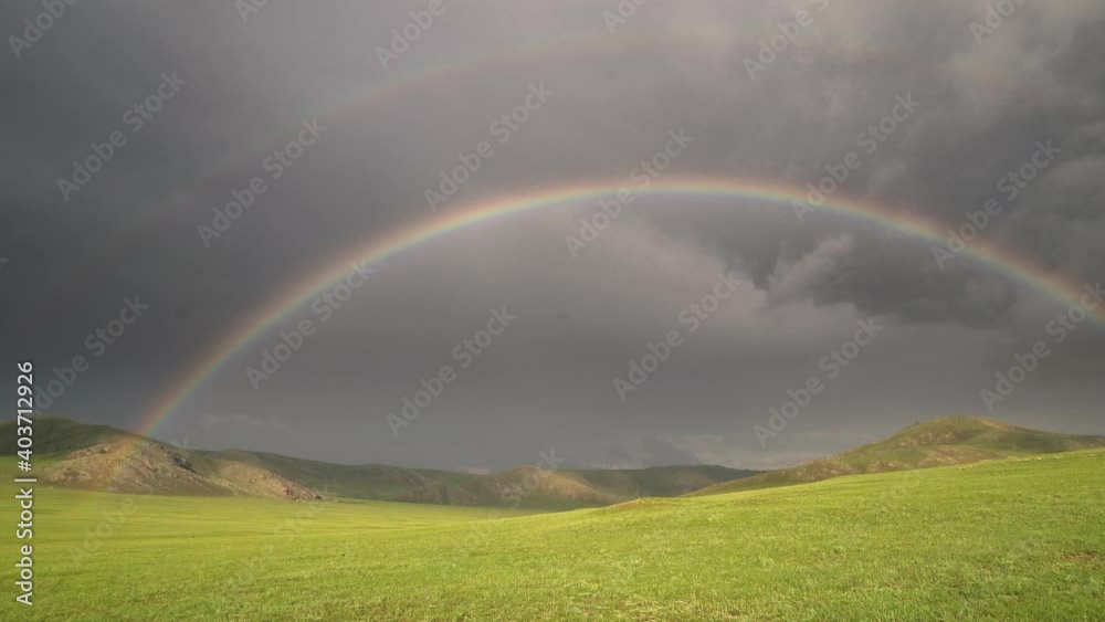 Colorful Rainbow in Vast Treeless Meadow.Circle grassland prairie meadow wold pasture steppe plateau tableland lowland plain treeless clear bright illuminated full navy blue curved 4K. Colorful Rainbow in Vast Treeless Meadow.Circle grassland prairie meadow wold pasture steppe plateau tableland lowland plain treeless clear bright illuminated full navy blue curved 4K.