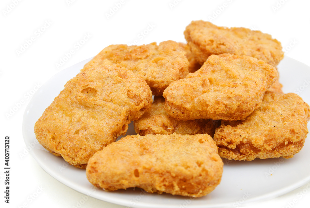 Fried chicken nuggets isolated in white plate on white