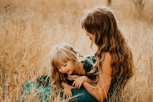 Mom hugs and laughs with her daughter in nature