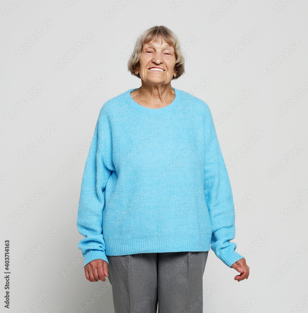 Full length portrait of a content senior lady smiling and looking at the camera Full length portrait of a content senior lady smiling and looking at the camera
