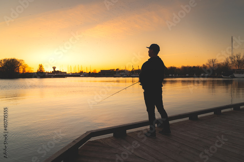 Photography Silhouette of an angler reeling in his line at sunset