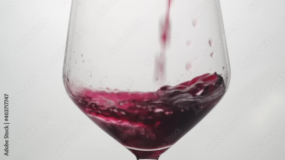 Sirviendo Vino tinto en una copa de cristal en cámara lenta.