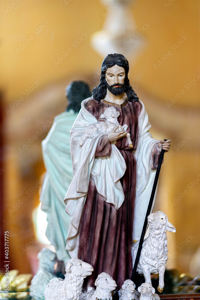 The statue of Jesus is photographed with his back to the mirror.