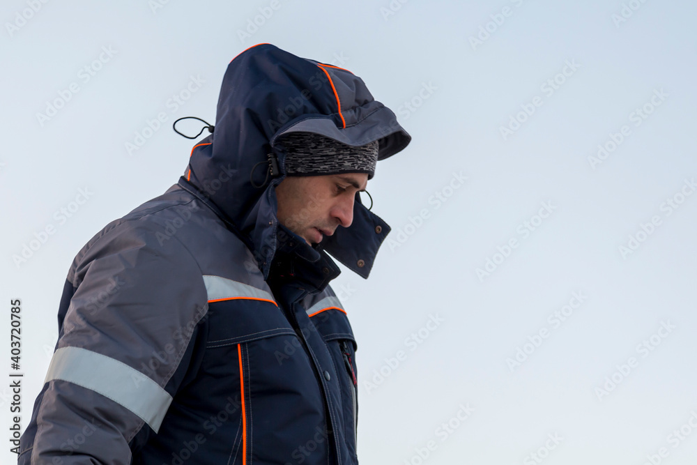 Portrait of a worker in a blue jacket with a hood Portrait of a worker in a blue jacket with a hood