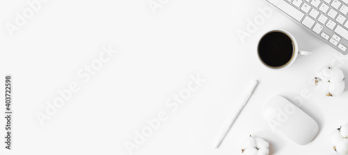 Minimal Office desk table with Keyboard computer, coffee cup, mouse, cotton flowers on a white table with copy space for input your text, White color workplace composition, flat lay, top view