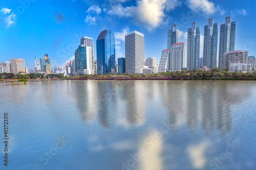 Cityscape of the office building reflaction of the water with bluesky at Benjakiti park ,Bangkok , Thailand. © witsawat