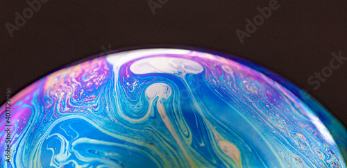 Closed up colourful wave and patterns with  rainbow effects in bubbles isolated on black background.