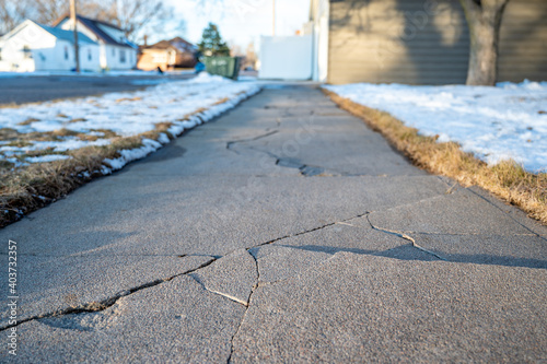 Frost heave crack in residential concrete sidewalk photo