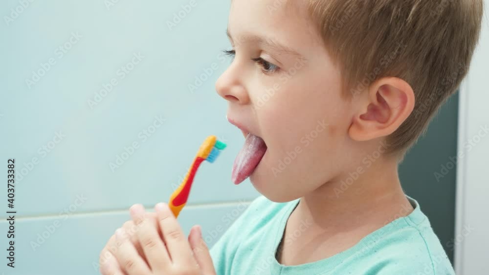 Portrait of little boy brushing teeth and cleaning tongue with toothbrush. CHild taking care of teeth and cleaning them Portrait of little boy brushing teeth and cleaning tongue with toothbrush. CHild taking care of teeth and cleaning them