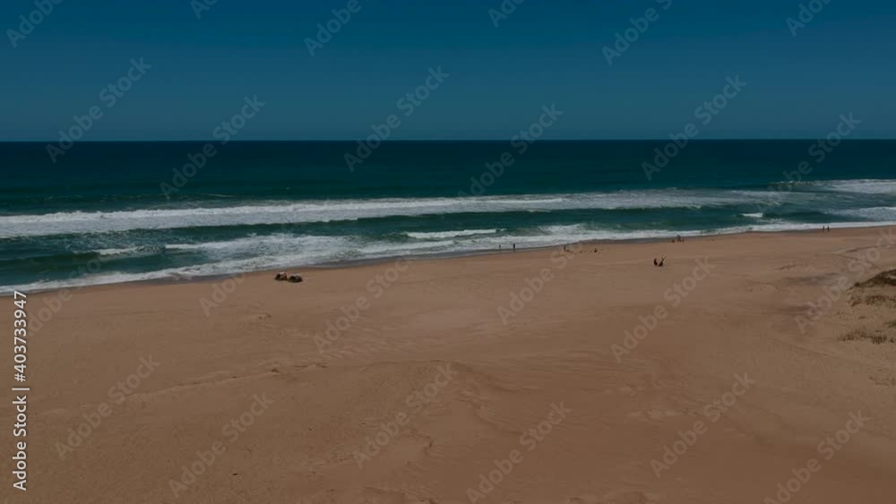 people walking along the empty Atlantica Rocha Uruguay beach on the sunny day people walking along the empty Atlantica Rocha Uruguay beach on the sunny day
