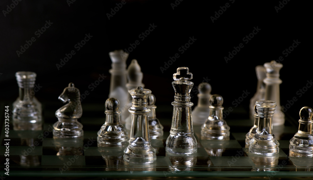 glass chess pieces are defending the king on board in dark glass chess pieces are defending the king on board in dark