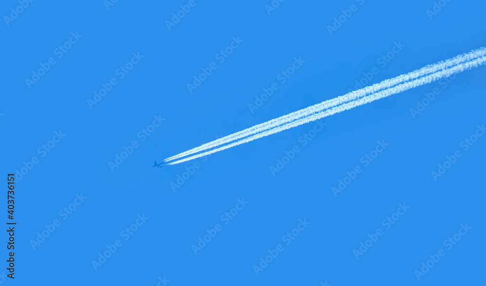 Trail of white smoke from the airplane on blue sky Trail of white smoke from the airplane on blue sky