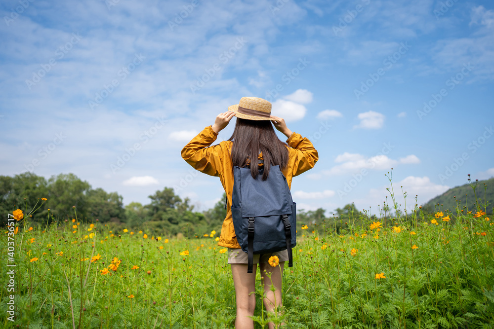 Young Asian women tourists relax in flower fields. She is traveling alone