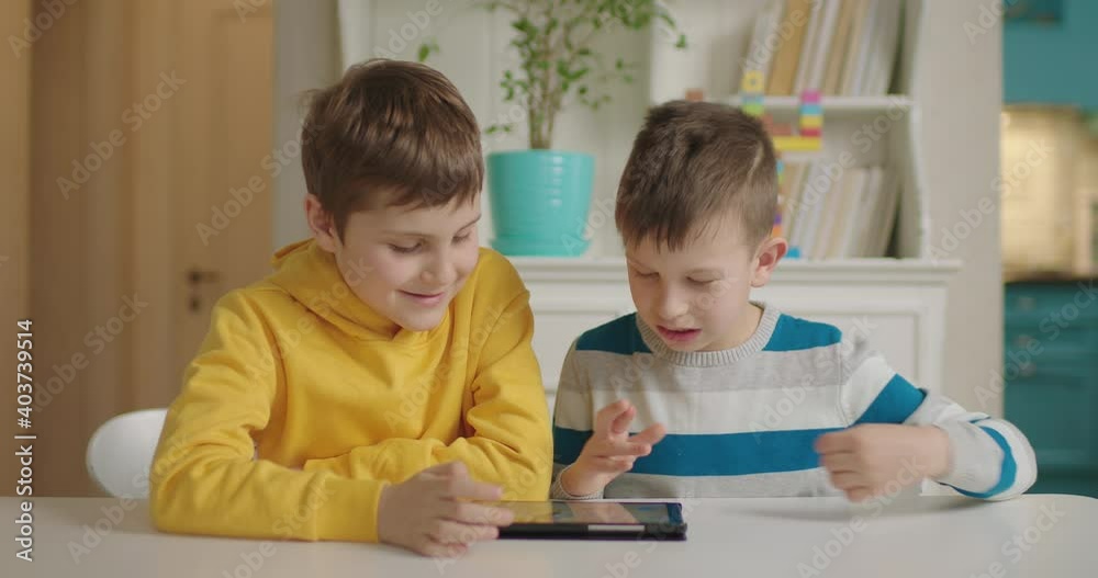 Two boys with autism using one tablet computer for education ...