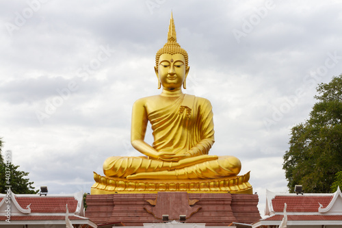 Beautiful Big Golden Buddha statue against blue sky in Thailand temple,khueang nai District, Ubon Ratchathani province, Thailand.Amazing Buddha image with sunny sky clouds.