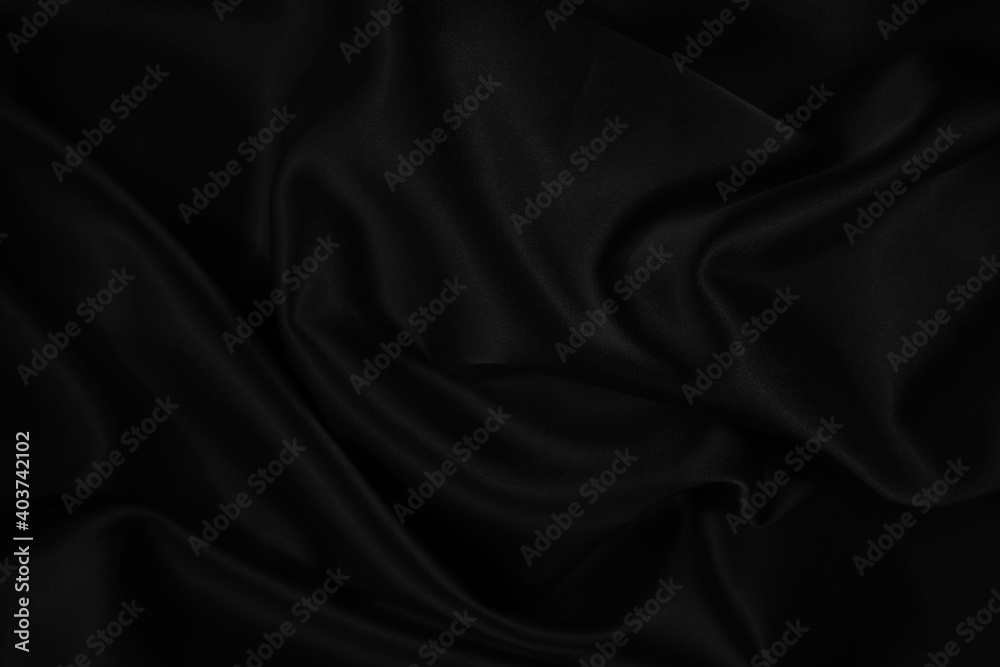 Fototapeta premium Black silk satin background. Dark elegant abstract background. Wavy soft folds on the fabric.