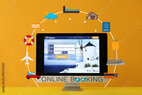Open page of online booking service on screen of computer monitor against color background