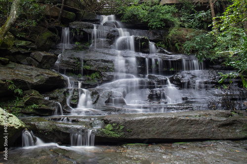 Tall rocky waterfall with good amount of water flowing.