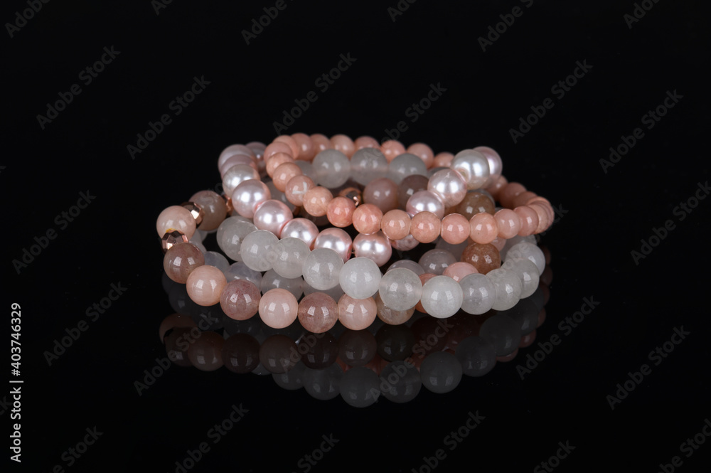 Fashion accessories. Jewelry on black reflective background. Gemstone bracelets. Natural stones beads.