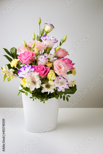 Wallpaper Mural mock up bouquet of roses, daisies, lisianthus, chrysanthemums, unopened buds in a white paper box on a white table and wall. Torontodigital.ca