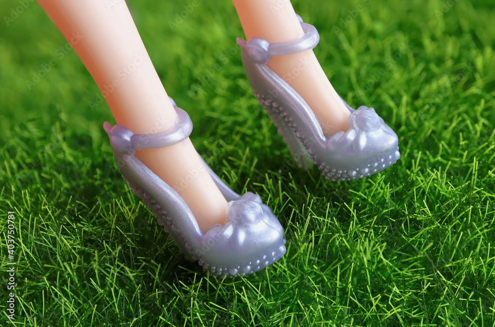 Long skinny legs of a plastic toy doll and high heels shoes. Doll shoes set. Fashion concept. Long skinny legs of a plastic toy doll and high heels shoes. Doll shoes set. Fashion concept.