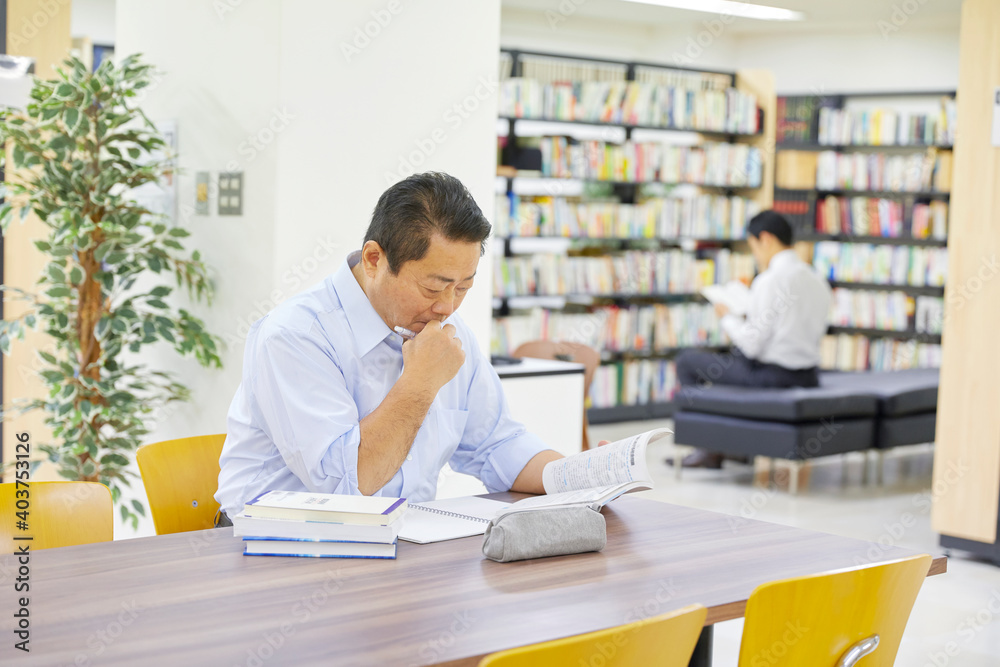 図書館で調べるものする男性 図書館で調べるものする男性