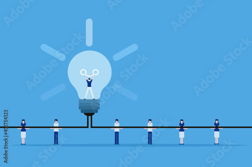 Conceptual illustration of a team helping a person to stand inside a light bulb to burn the filament as a symbol of generating ideas photo