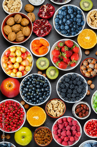 Food for a healthy diet: berries, fruits, nuts, dried fruits. Black concrete background